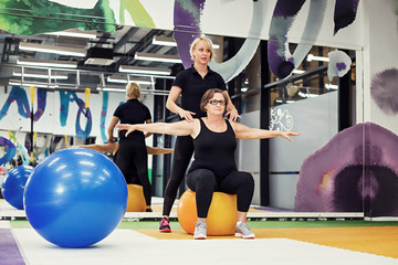 Senior woman exercising with personal trainer