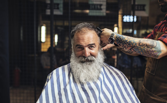 Bearded man getting hair cut