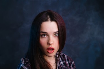 Shocked and surprised girl screaming and looking at the camera. Dark haired woman amazed. Expressive facial expressions