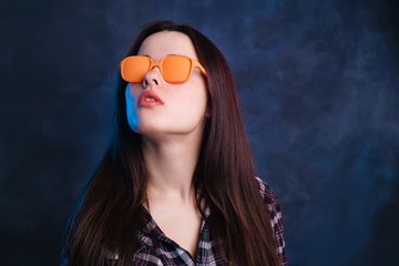 Young beautiful stylish woman in orange vintage sunglasses. Fashion and beauty concept
