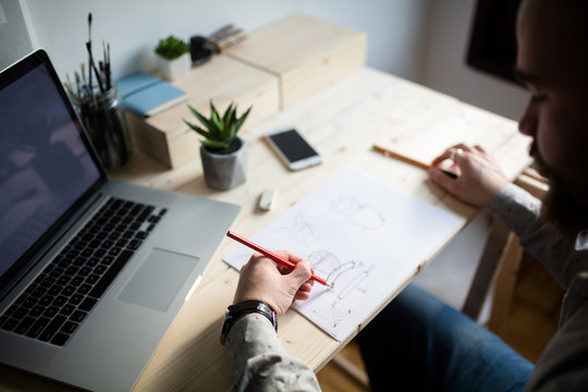 Graphic designer drawing on paper