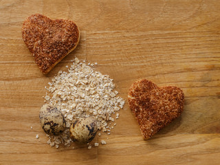 oatmeal and eggs and cinnamon cookies hearts on wooden table