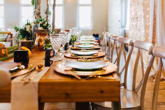 A venue set up for a wedding reception with copper and green colored decor.