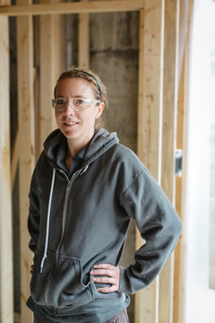 Portrait of young electrician woman smiling at camera on jobsite