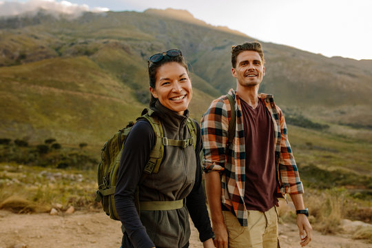 Smiling woman hiking in nature with boyfriend