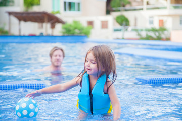 Father keeps an eye on his daughter in the swimming pool
