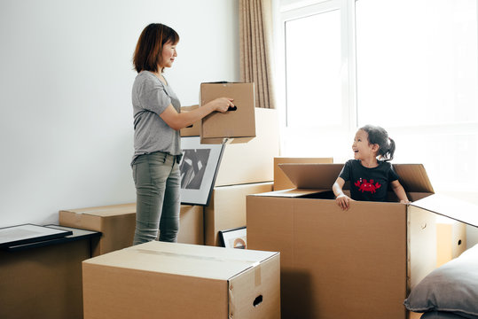 Young woman moving boxes in new home