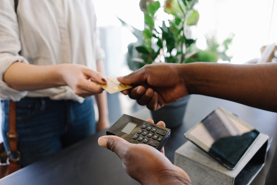 Woman paying bill through credit card at checkout counter