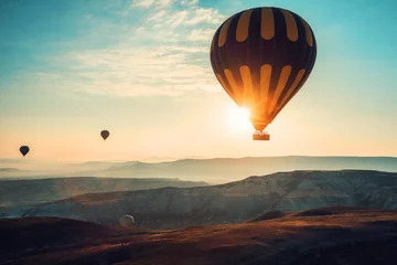 Fotobehang Ballon Heteluchtballonnen vliegen over de vallei bij Cappadocië.