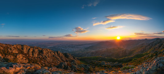 Fototapeta na wymiar Beautiful sunset over the mountain hills and city, aerial panoramic view