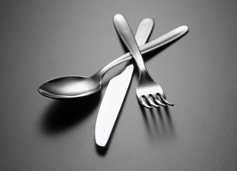 Spoon, knife, fork on grey background