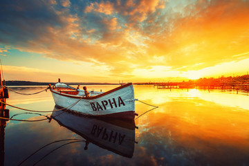 Fishing Boat on Varna lake with a reflection in the water at sunset