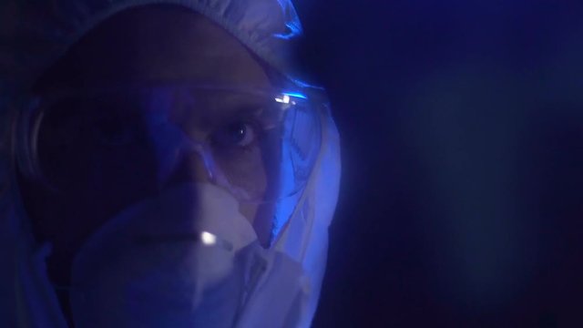 Secret agent in protective goggles spraying liquid and erasing hand prints