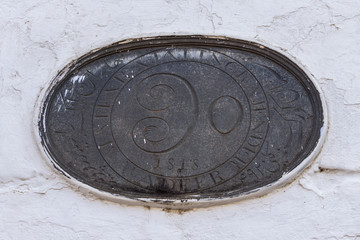 Madikeri, India - October 31, 2013: Shree Omkareshwara Temple. Sanctuary and local royal symbol and seal edged on an oval stone set in white wall.