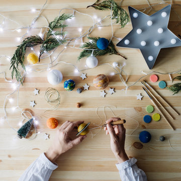 Overhead view of woman making garland of planets