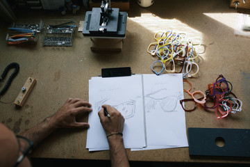 Artisan eyewear designer drawing some glasses designs