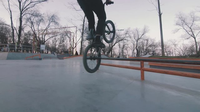 bmx rider doing tricks in concrete skatepark, slow motion
