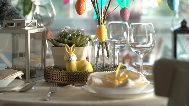 Young woman is setting easter festive table with bunny and eggs decoration. Slow Motion