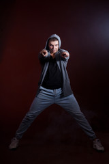 Hip-hop dancer on a dark background in the studio