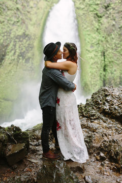 Adventurous Couple Kissing at Waterfall