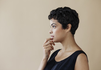 Profile of young woman on beige backfround.