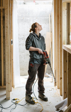 Young electrician woman working on the job