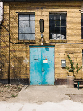 Closed Turquoise Metal Door in Old Exposed Brick Factory Buildin