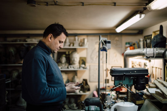 Man using a mobile phone in his workshop