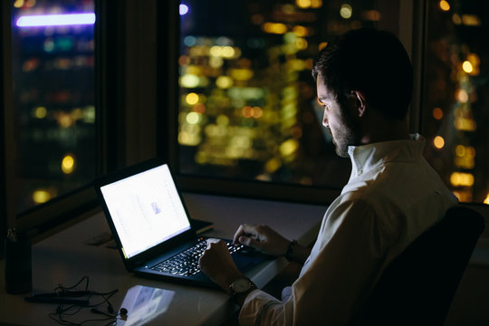 Man working on laptop late at night.