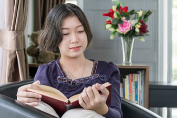 Young asian woman short hair read a book in living room