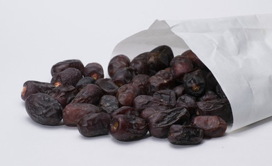 dates in a paper bag on a white background