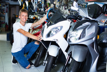 Fototapeta na wymiar Portrait of adult man purchaser choosing motorbike