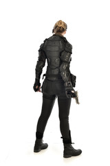full length portrait of female  soldier wearing black  tactical armour, holding a gun, isolated on white studio background.