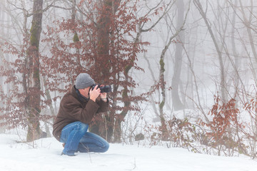 Nature photographer in winter forest