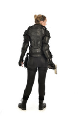 Fototapeta premium full length portrait of female soldier wearing black tactical armour, holding a gun, isolated on white studio background.