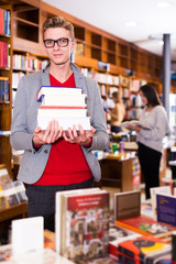 Guy holding books in store