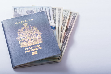 A Canadian Passport with US currency ready for cross border travel and shopping, tourism and travel concept.