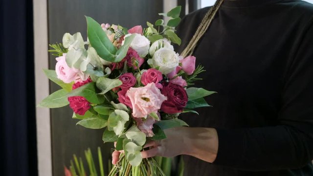 Flower shop. Female florist arranging modern bouquet of fresh flowers. 4K