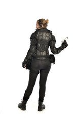 full length portrait of female  soldier wearing black  tactical armour, holding a gun, isolated on white studio background.