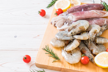 Fototapeta na wymiar fresh seafood raw (shrimps ,squids) on wooden board