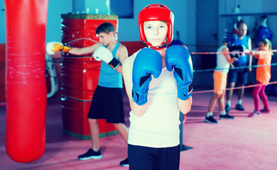 Young serious teenager with boxing gloves