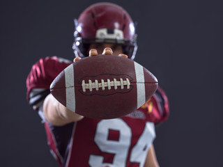 american football player showing football to camera