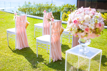 Wedding chair decorated with flowers on the lawn.