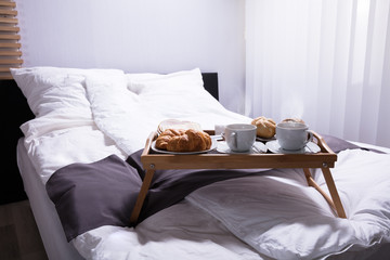 Croissants And Cup Of Tea On Bed