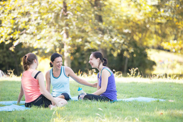 Fototapeta premium Families with young Russian mother and daughter are talk about exercise. After practice yoga at the park finished. Health and Fitness concept