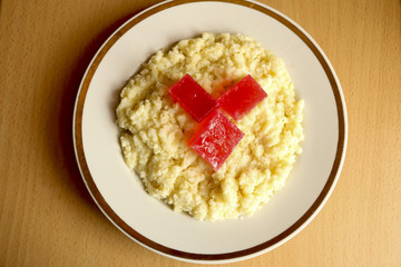 useful breakfast. wheat porridge with marmalade. golden gruel from millet with pieces of fresh fruit jelly.