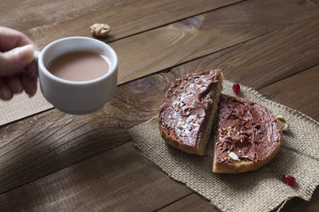 sweet breakfast of sandwich with chocolate and hot cocoa in hand