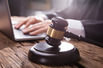 Close-up Of A Gavel On Wooden Desk