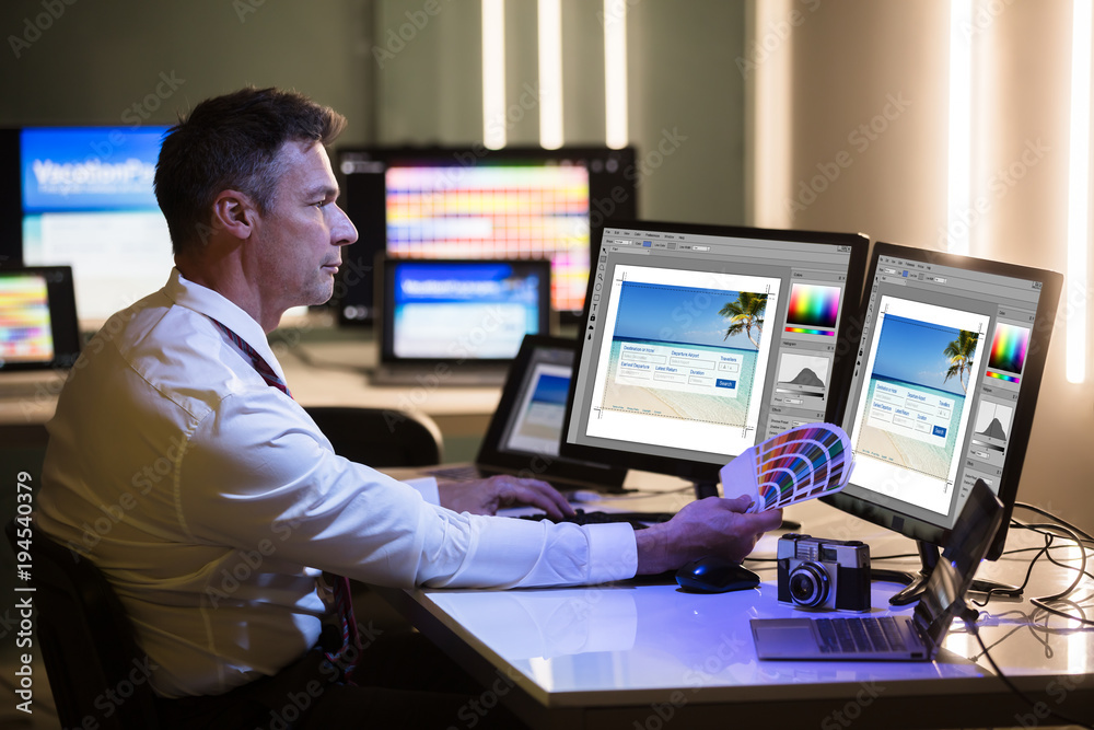 Poster Designer Holding Colorful Swatch Working On Computer