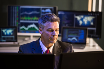 Stock Market Broker Looking At Multiple Computer Screen